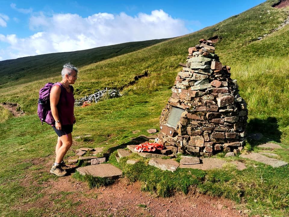 Walker beside a stone cairn